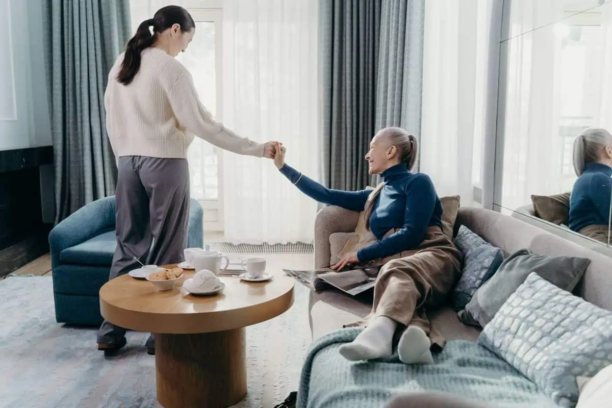 Daughter helping her elderly mother at home, a family considering why place your loved one in an aged care facility
